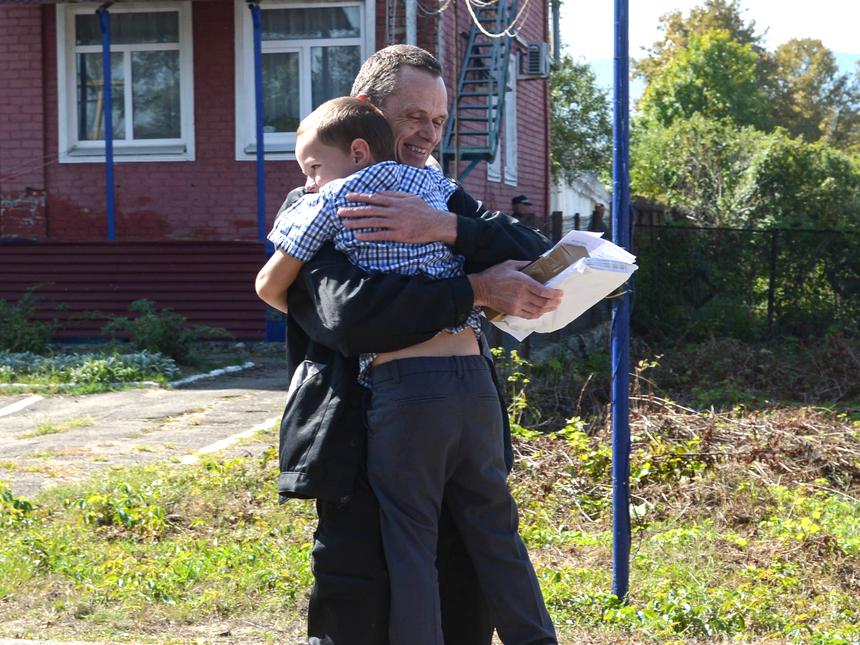 The believer hugs his younger son